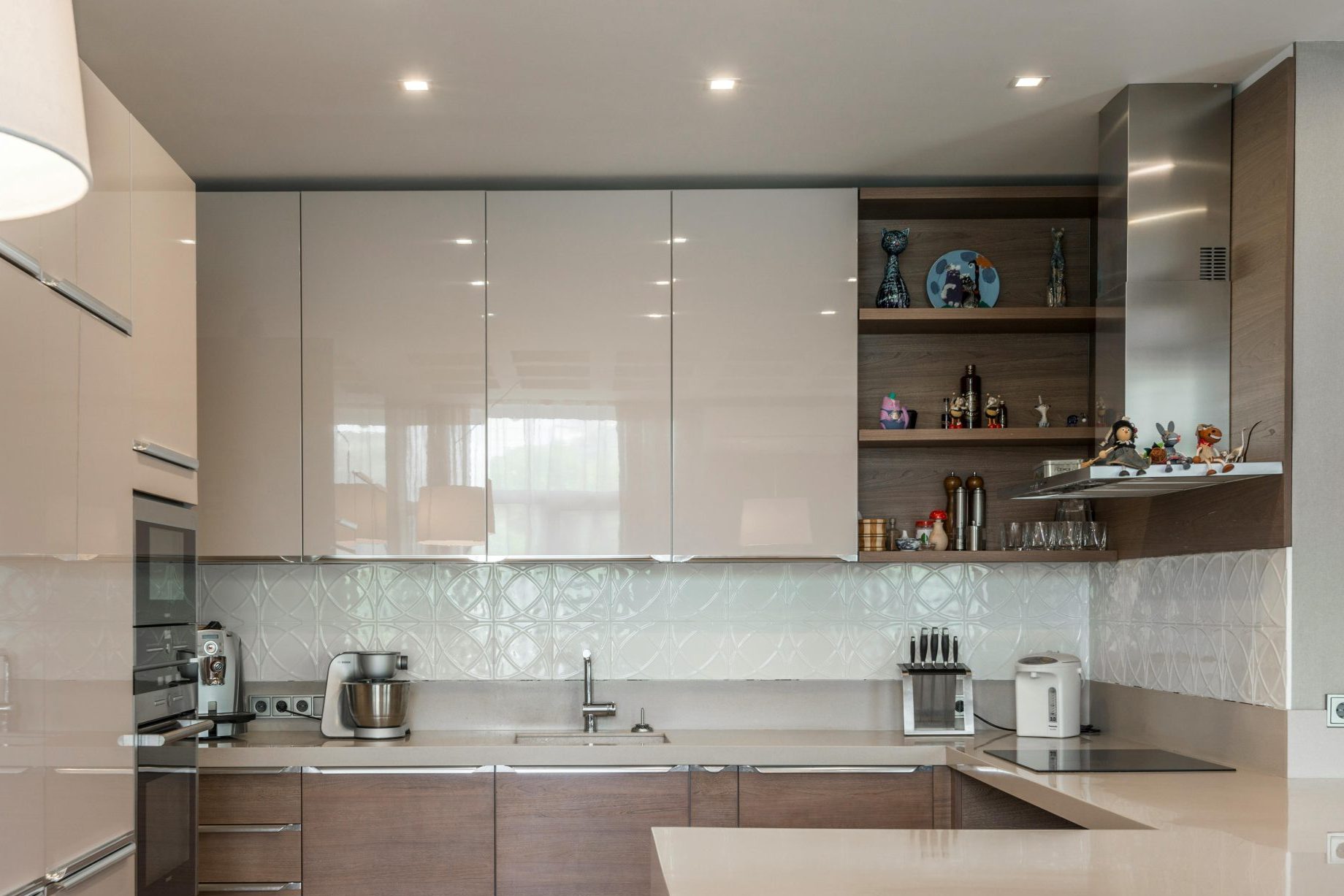 Sleek modern kitchen with white cabinets, island, and built-in appliances.
